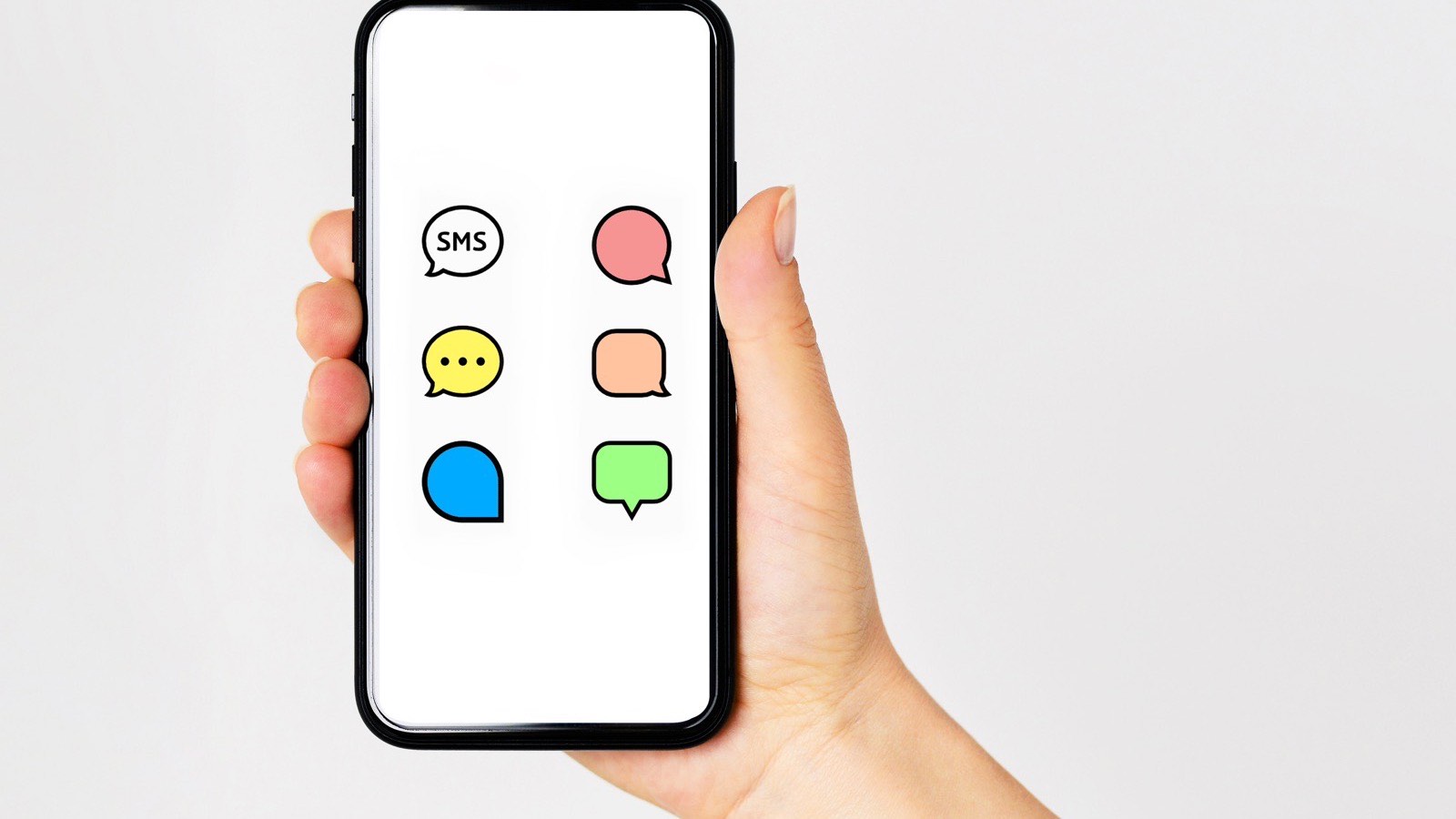 Mão segurando um celular com balões de conversa coloridos na tela, lembrando uma consulta a um assistente de IA